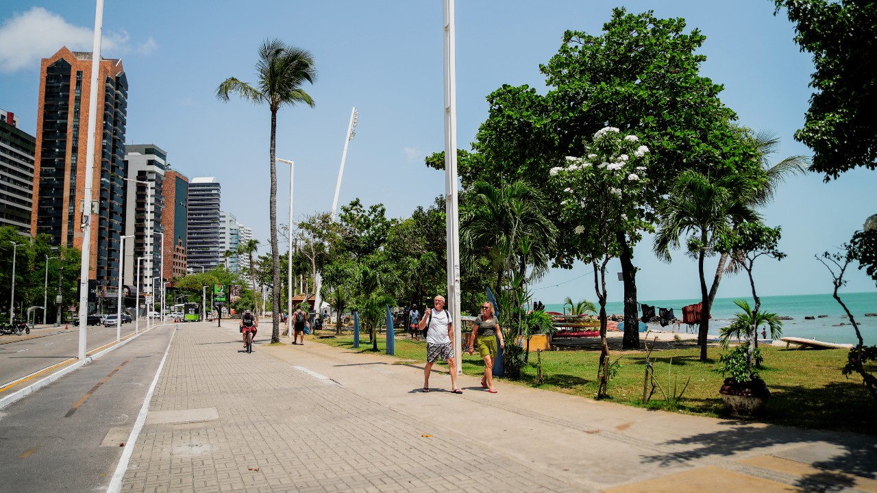 pessoas caminhando no calçadão da avenida beira-mar